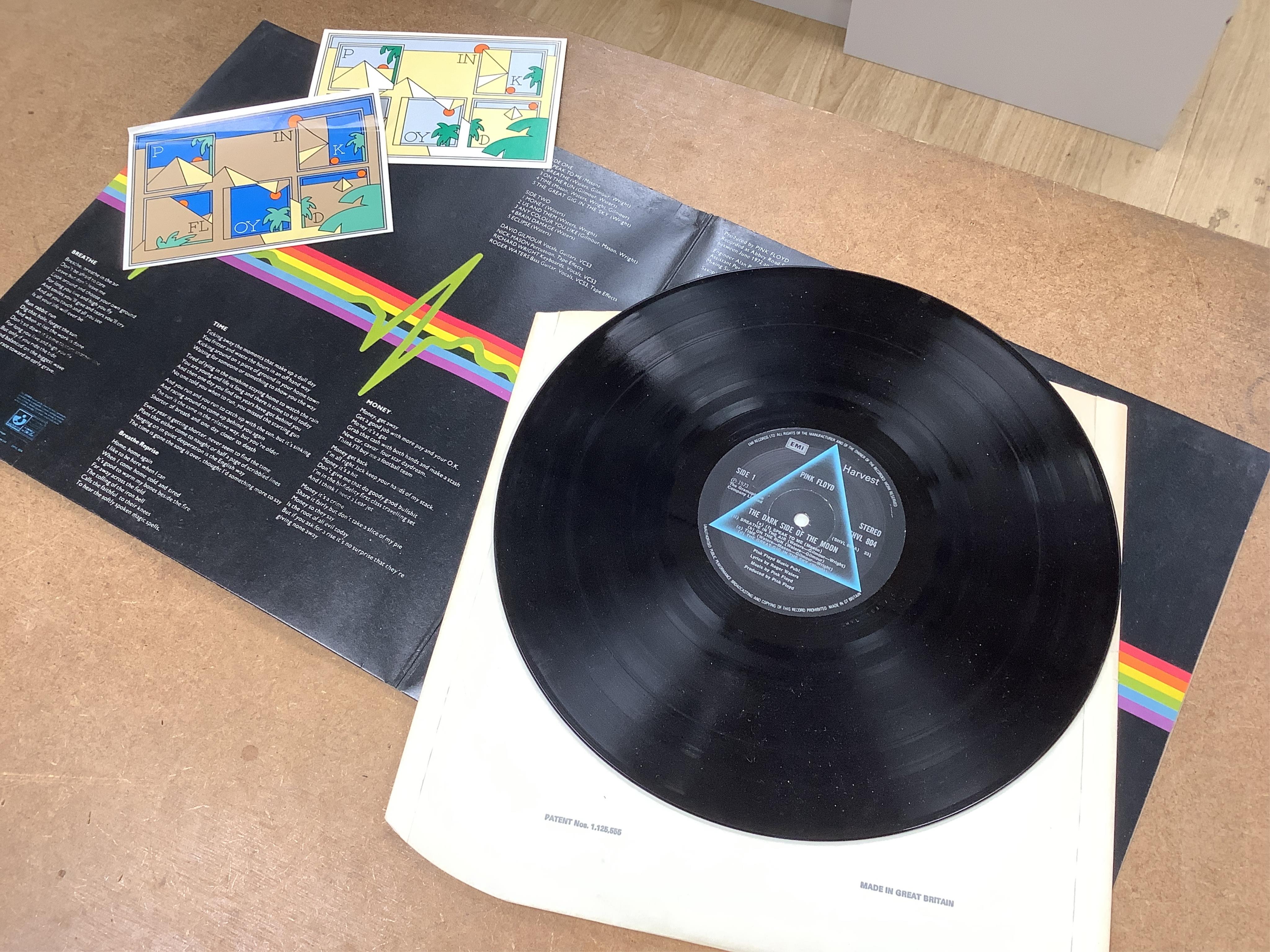 Three Pink Floyd LP record albums; The Wall, SHDW 4111, Dark Side of the Moon, SHVL804, with both posters and two postcards, Atom Heart Mother, SHVL781